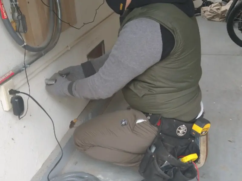 Electrician performing outlet wiring in a North Canaan garage